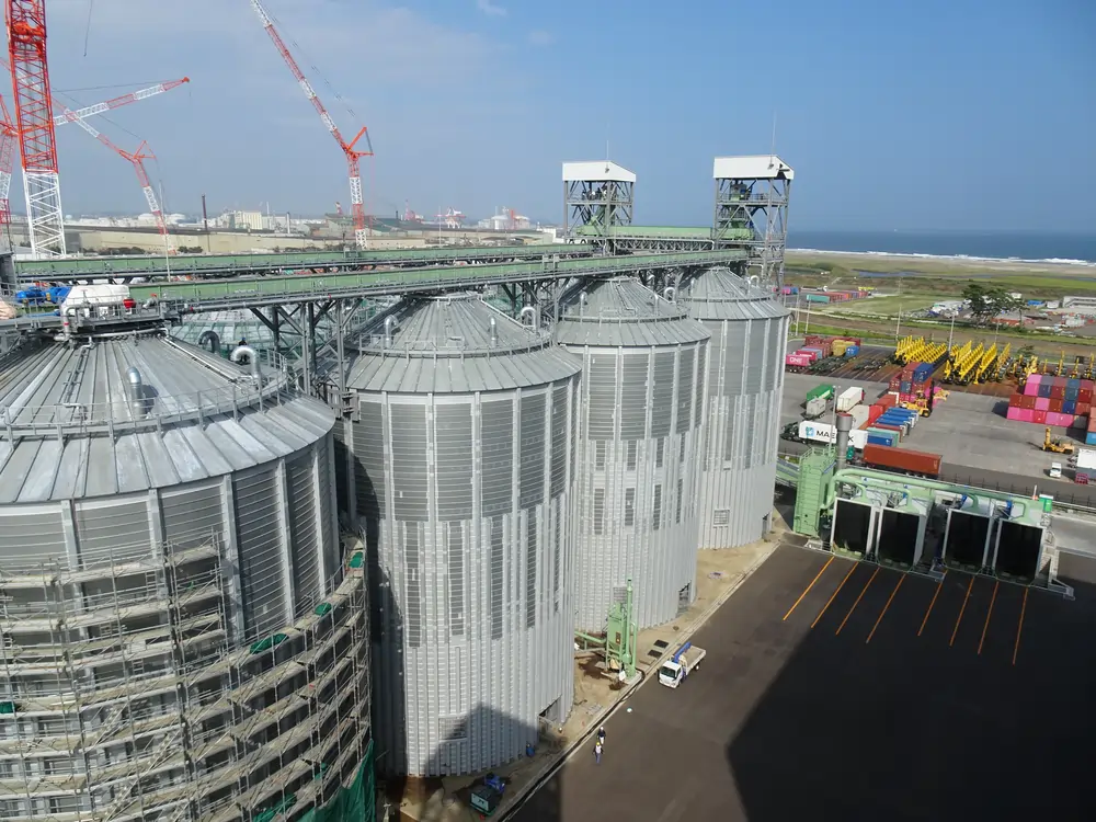 BUMATECH-Industrial bolted silos installation at a bulk materials handling terminal near the coast.